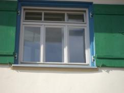 Holz-Fenster in weiß mit grünen Klappläden