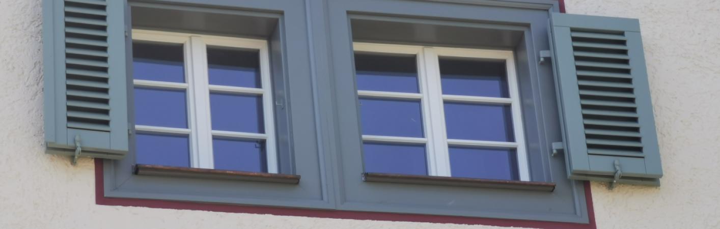 Sprossenfenster in weiß mit Klappläden in grau